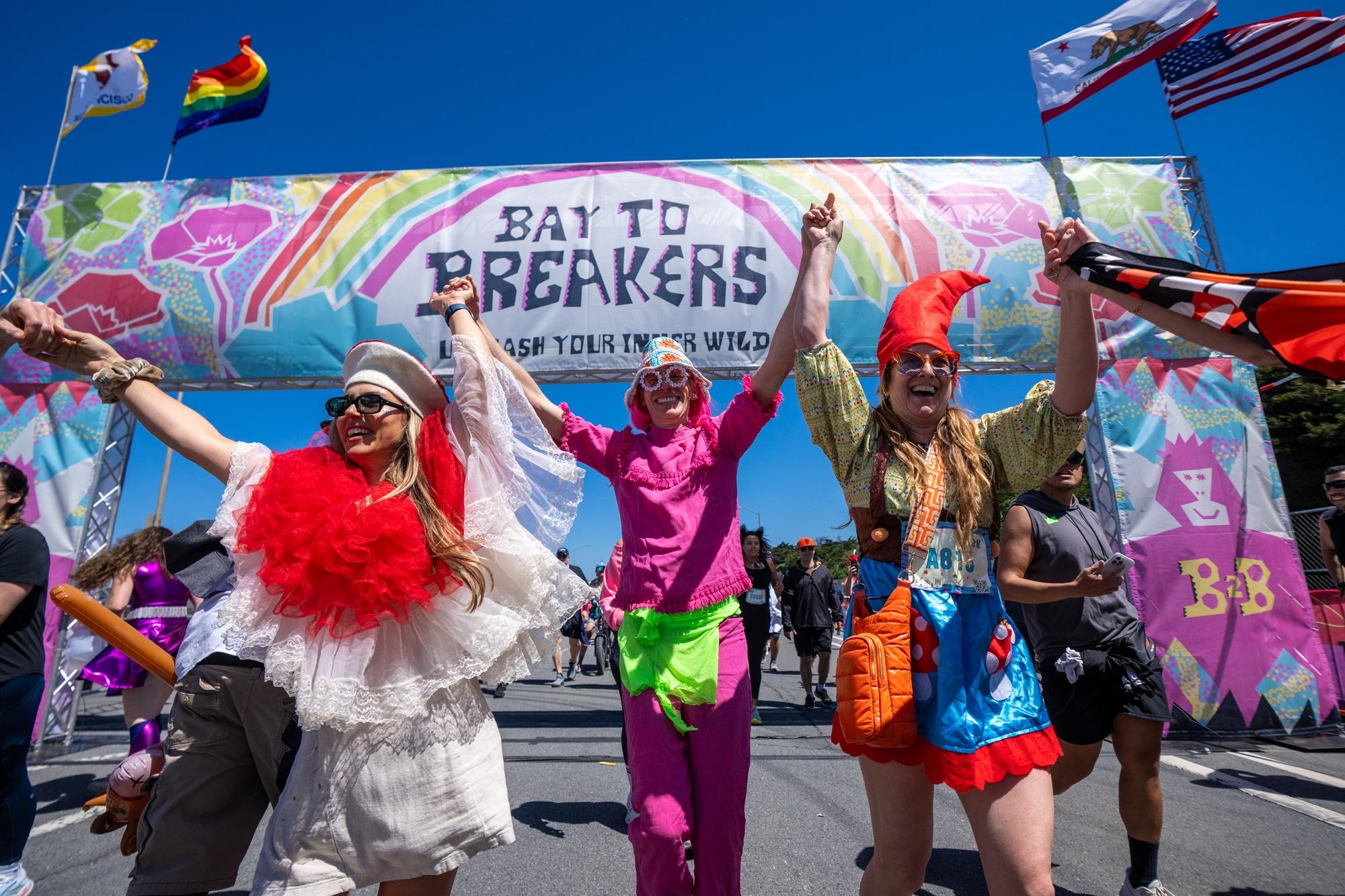 Costumed participants crossing the Bay to Breakers finish arch