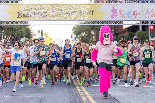 Runners and a costumed gorilla crossing the Bay to Breakers start line
