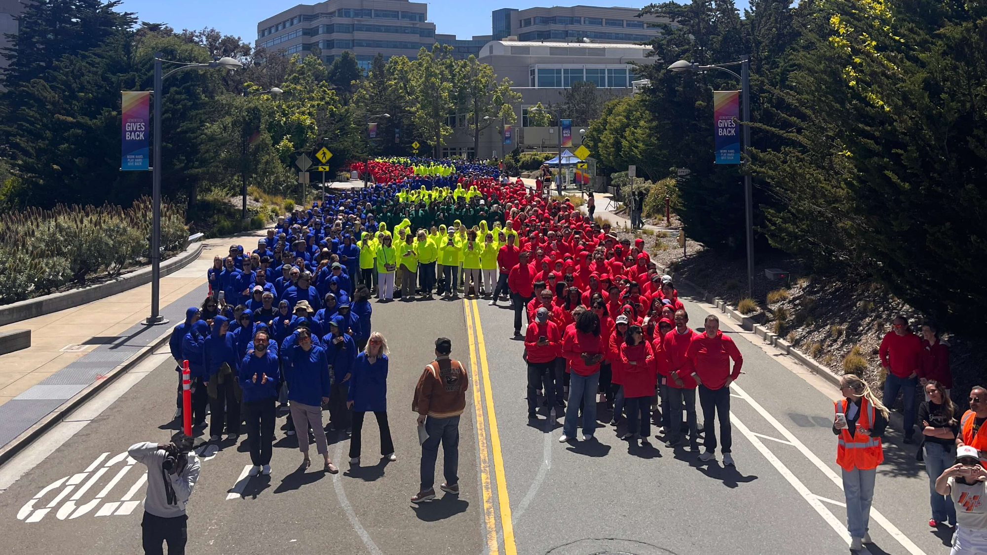 Genentech employees in colored hoodies forming the record-breaking human DNA helix on DNA Way