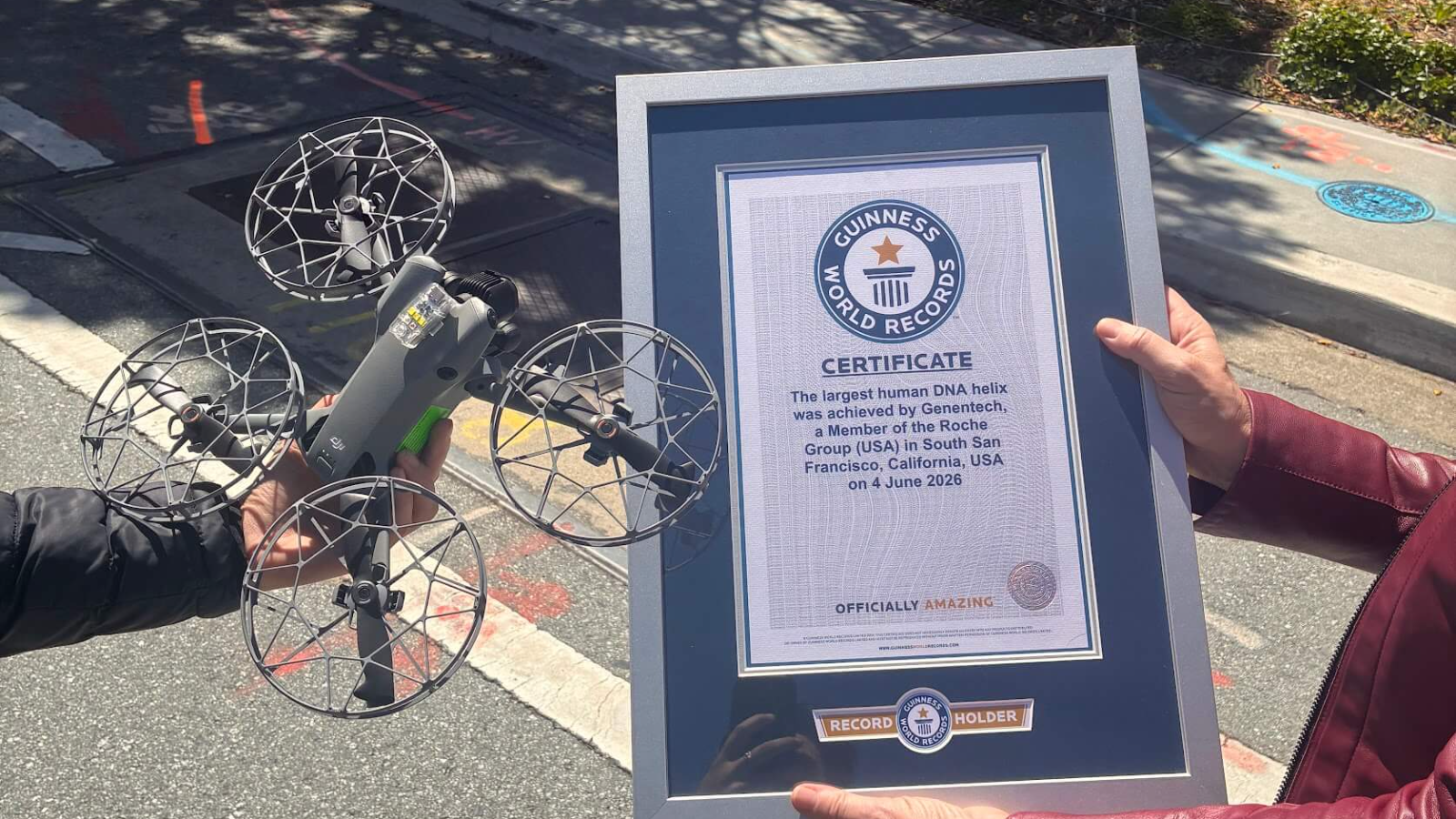 Guinness World Records certificate held beside the drone that captured the attempt